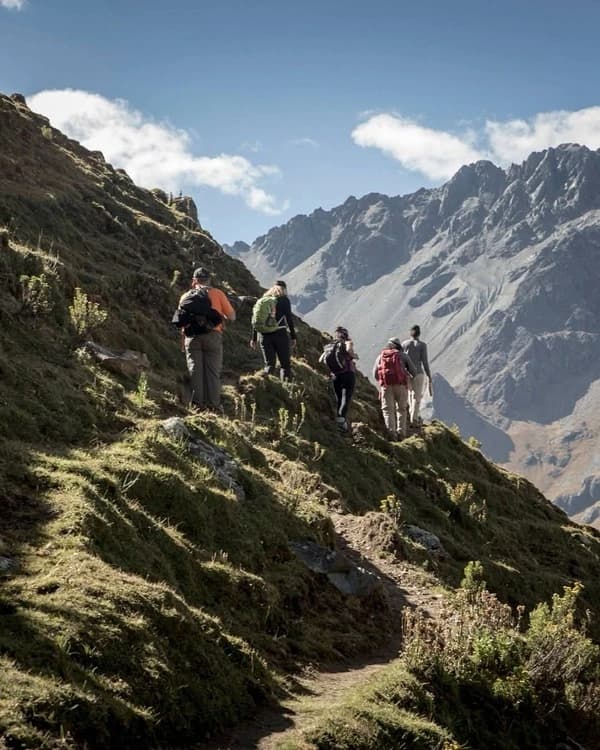 Grupo de viajeros caminando por una ruta de montaña en los Andes