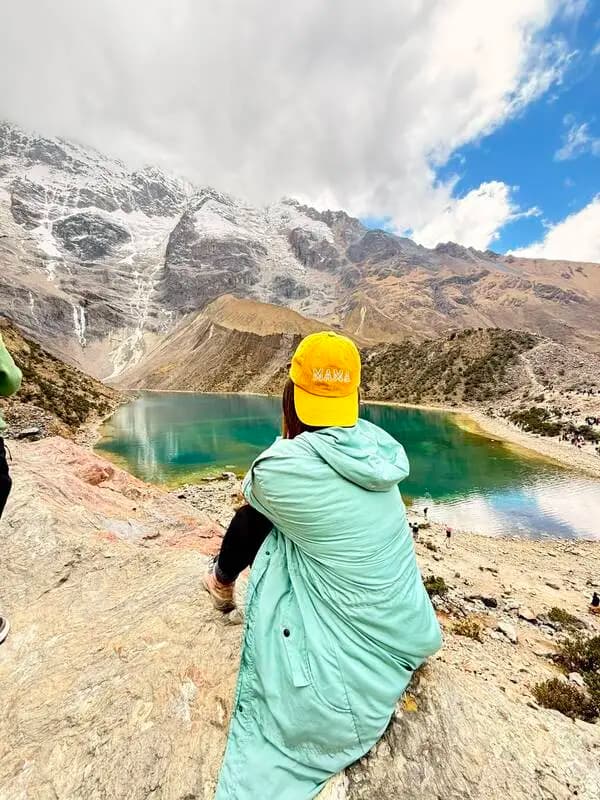 Viajera contemplando la Laguna Humantay y las montañas nevadas